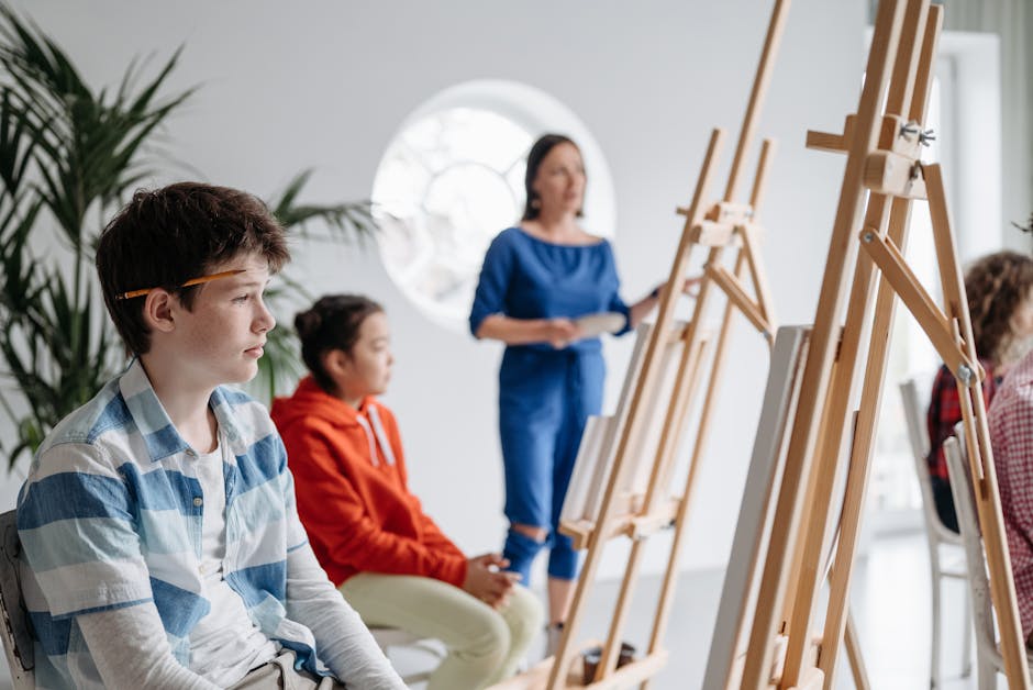 Children attentively participate in an art class, learning painting with easels and a teacher's guidance.